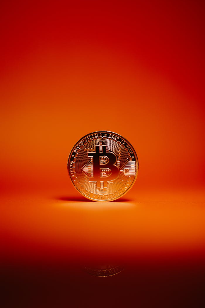 Mastering the First Impression: Your intriguing post title goes here Close-up of a Bitcoin coin against a striking orange background, symbolizing digital currency and investment.